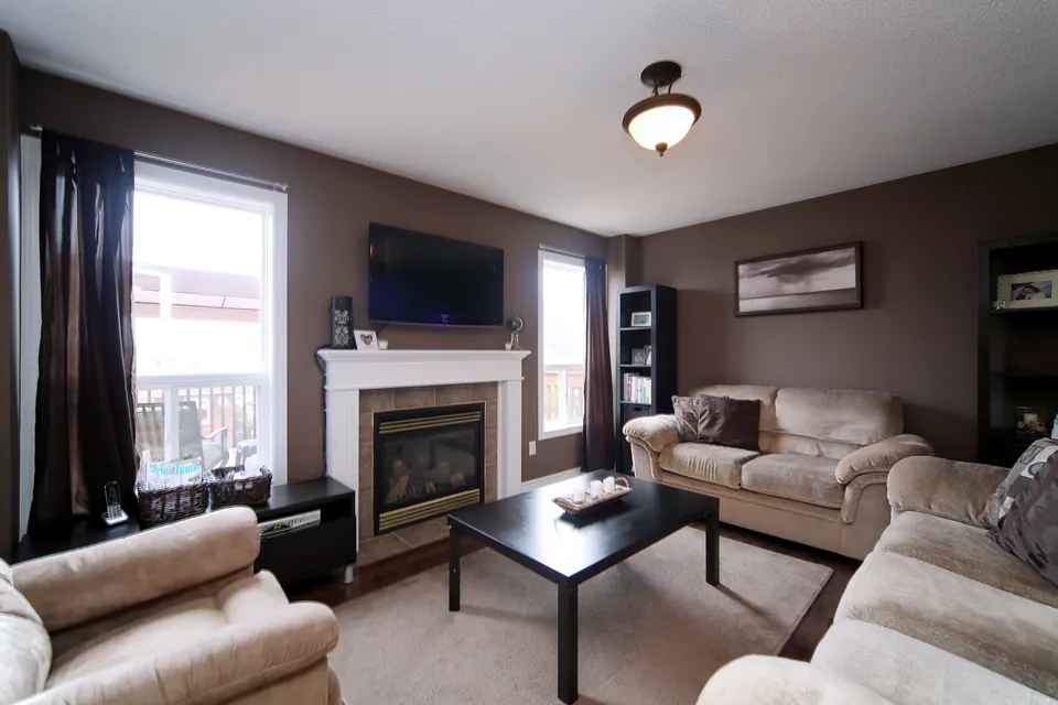 A family room with a fireplace and warm taupe walls