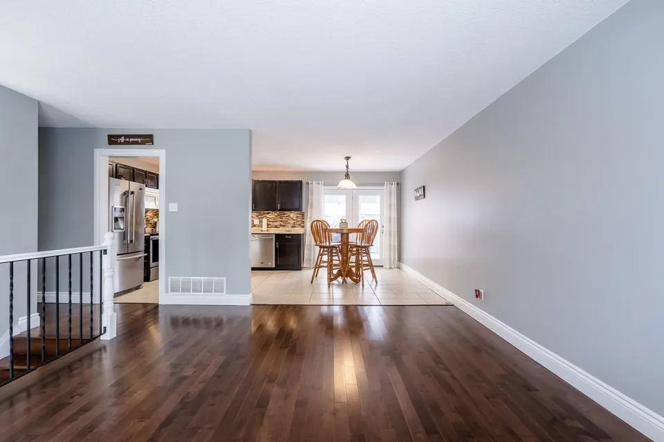 A long living room with fresh grey walls leading to the dining area