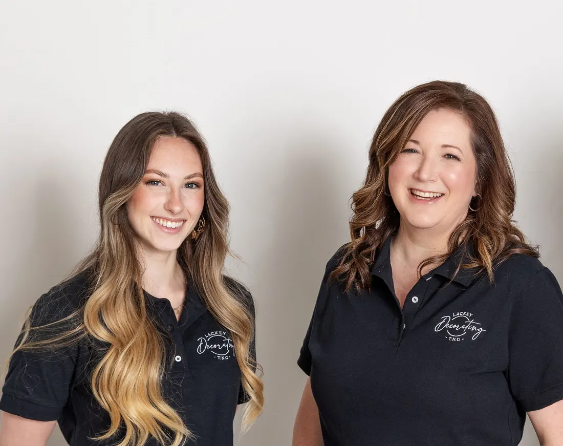 Melissa and Taylor of Lackey Decorating T.N.G, smiling in their branded work shirts